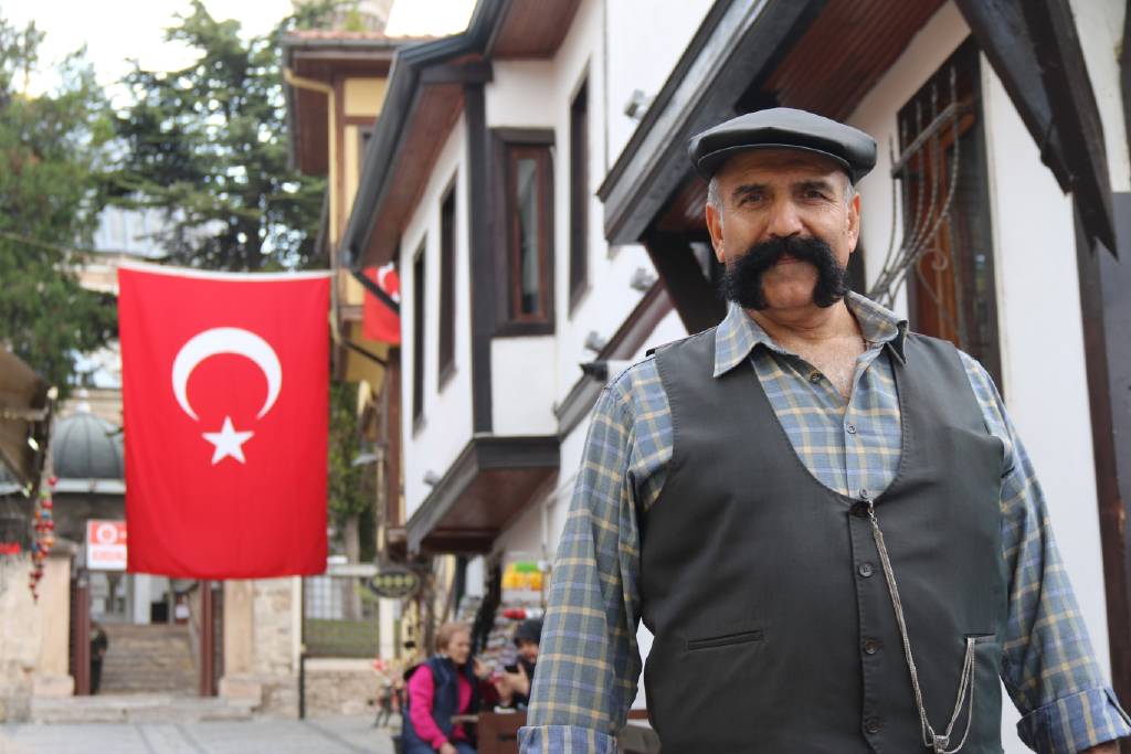 20 yıllık bıyıkları, kasketi, çizmeleri ve tespihi ile şehirleri dolaşıyor…